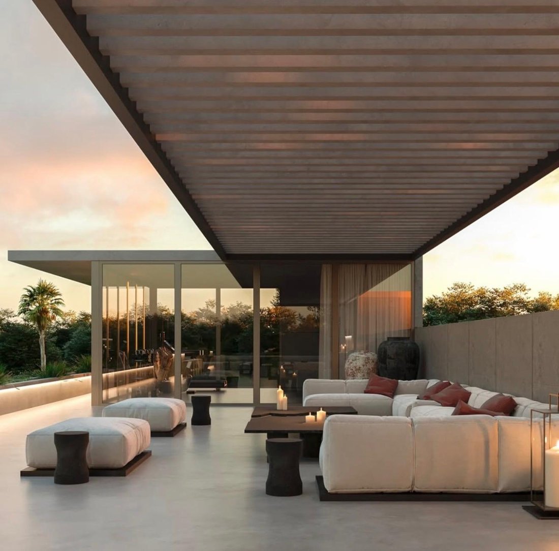 Überdachte Terrasse mit Loungemöbeln in der Abenddämmerung